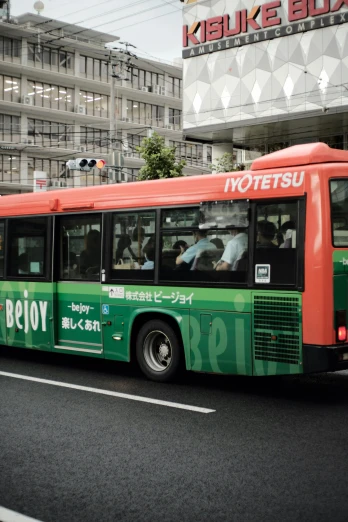 a green and red bus driving down a street, by Itō Seiu, unsplash, sōsaku hanga, 2 5 6 x 2 5 6 pixels, hydrogen fuel cell vehicle, advertising, japanese model