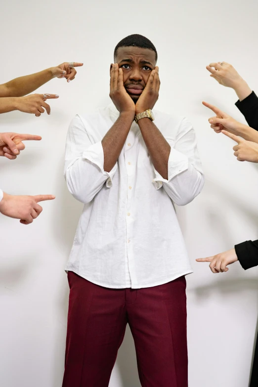 a man standing in front of a group of people, by Nina Hamnett, trending on pexels, renaissance, facepalm, kayne west, plain background, power pose