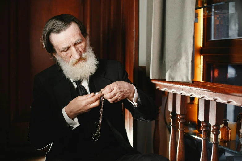 a man with a white beard wearing a suit and tie, an album cover, inspired by Francisco Oller, unsplash, hyperrealism, strings of pearls, orthodox christianity, looking at his phone, still image from tv series