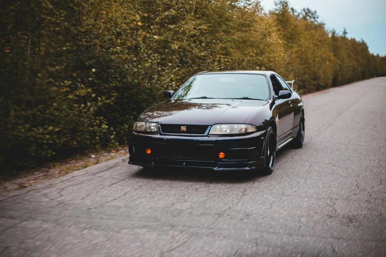 a black car parked on the side of a road, a portrait, unsplash, japanese drift car, 2000s photo, long front end, gtr xu1