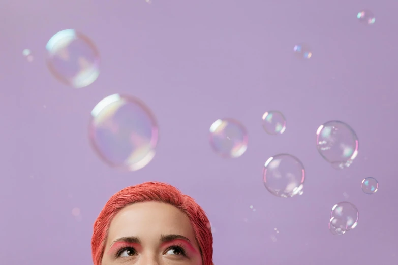 a woman with red hair blowing bubbles in the air, an album cover, inspired by Pearl Frush, trending on pexels, short purple hair, photoshoot for skincare brand, eye level view, solid background