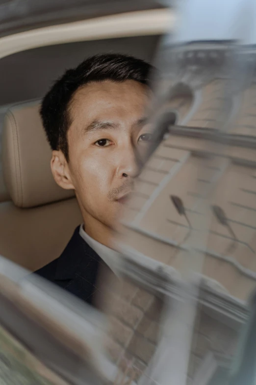 a man in a suit sitting in a car, an album cover, inspired by Fei Danxu, pexels contest winner, exhausted face close up, discord profile picture, wonbin lee, birdseye view