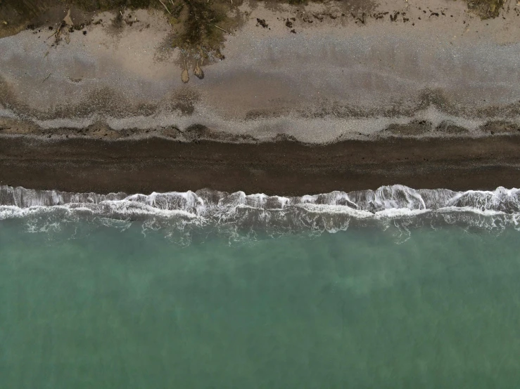 a large body of water next to a sandy beach, inspired by Andreas Gursky, pexels contest winner, dark brown white green colours, top down perspecrive, detailed photoreal, ignant