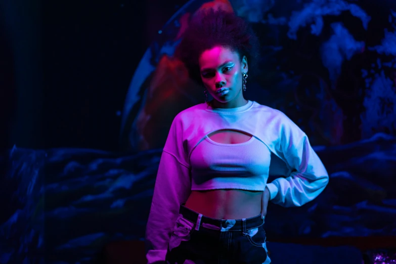 a woman standing in front of a painting, an album cover, afrofuturism, crop top, pink and blue lighting, movie still 8 k, woman in streetwear