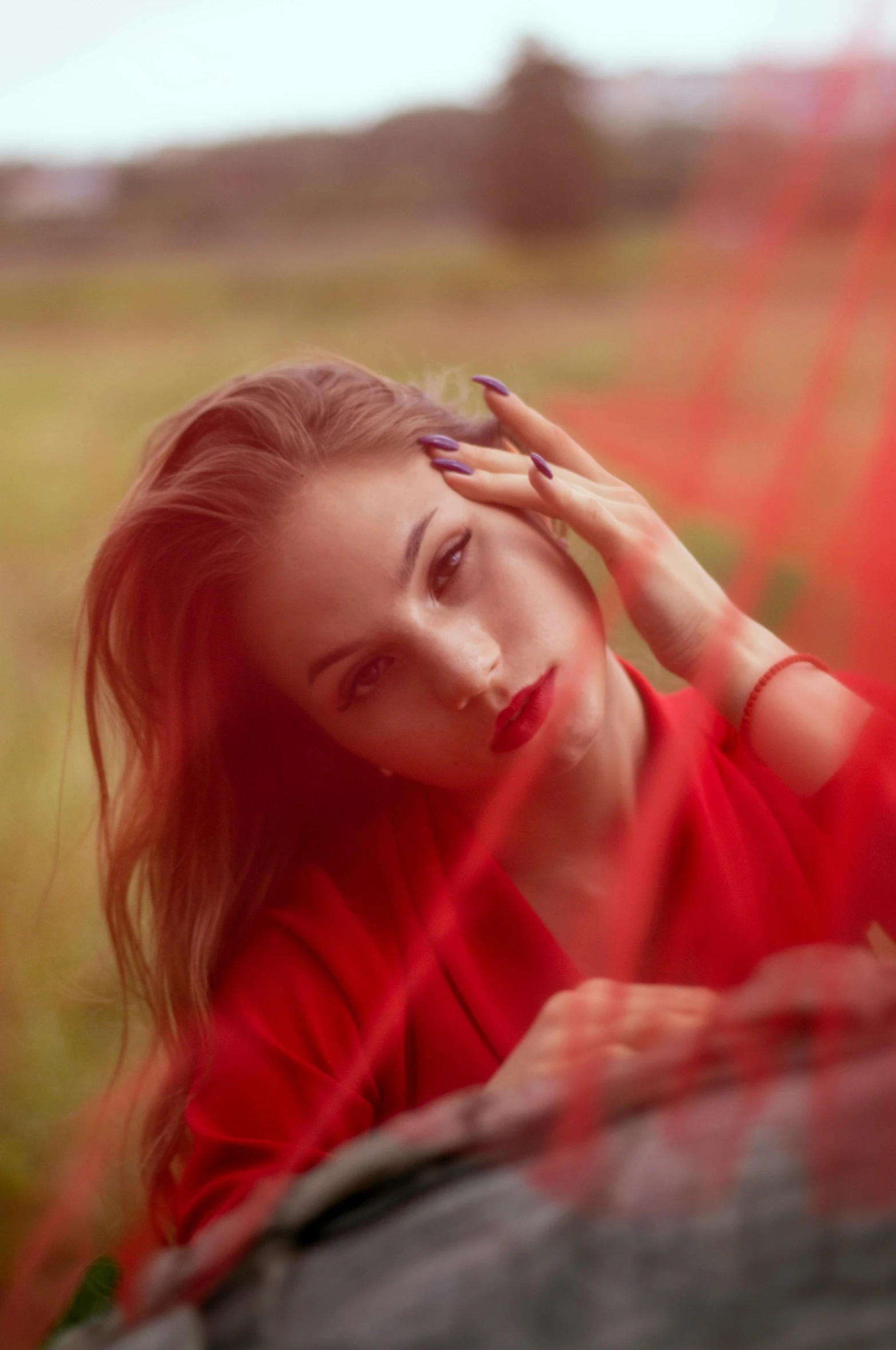 a woman in a red shirt leaning on a rock, inspired by Elsa Bleda, pexels contest winner, light-red lips, her hands are red roots, 15081959 21121991 01012000 4k, portrait sophie mudd