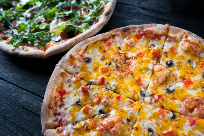 a couple of pizzas sitting on top of a wooden table, up close, buzzed sides, a blond, california;