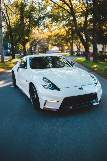 a white sports car driving down a street, pexels contest winner, extreme shitty car mods, frontal pose, samurai vinyl wrap, instagram post