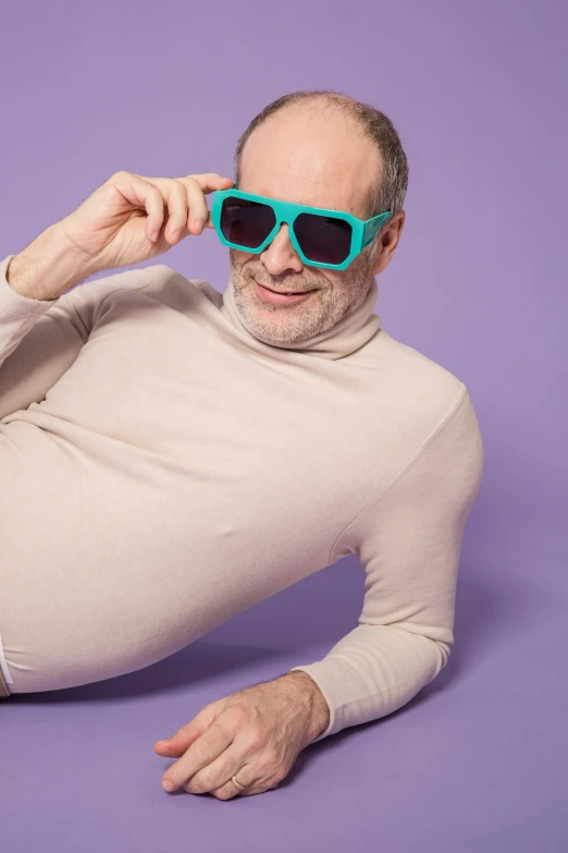 a man laying on the ground wearing sunglasses, inspired by Bert Stern, trending on tumblr, superflat, mauve and cyan, wearing turtleneck, bob odenkirk, official product photo