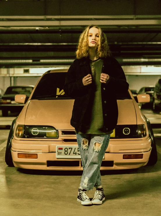 a woman standing in a parking garage next to a pink car, an album cover, inspired by Elsa Bleda, unsplash, renaissance, wearing japanese techwear, portrait shot 8 k, japanese drift car, low quality photo