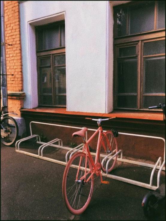 a red bicycle parked in front of a building