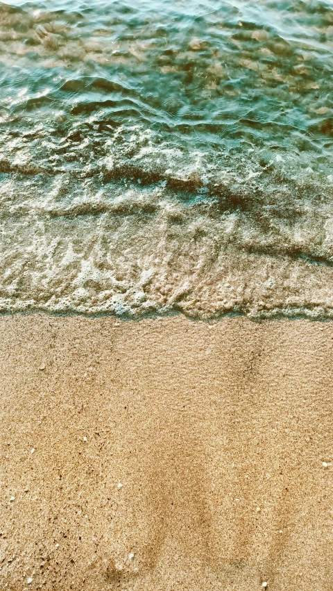 a surfboard sitting on top of a sandy beach, an album cover, pexels, extremely detailed water texture, high angle close up shot, brown skin like soil, slide show