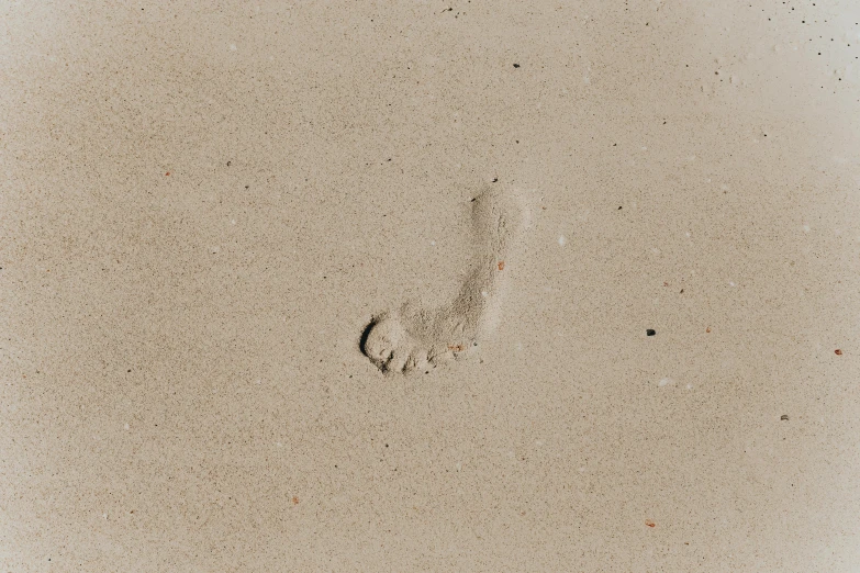 a foot print in the sand on a beach, pexels, minimalism, background image, taupe, falling sand inside, pregnancy