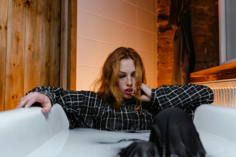 a woman with red hair sitting in a bathtub, inspired by Elsa Bleda, trending on pexels, drunk cowboy redhead long hair, sitting on a couch, scary mood, wet shirt