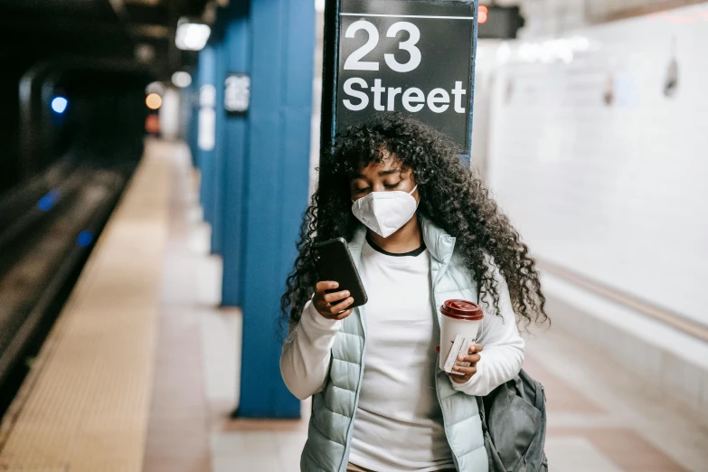 a woman with a face mask looking at her phone, trending on pexels, mta subway entrance, avatar image, sza, fan favorite