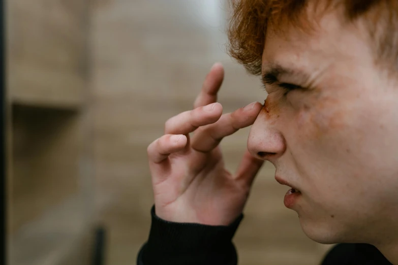 a close up of a person holding a cell phone to their ear, by Daniel Lieske, trending on pexels, hyperrealism, red haired teen boy, black spot over left eye, coughing, side view of a gaunt
