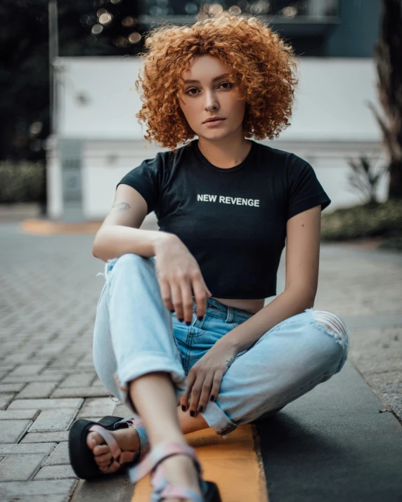 a woman sitting on the ground with a skateboard, trending on pexels, renaissance, black t shirt, with a curly perm, proud serious expression, 🤤 girl portrait