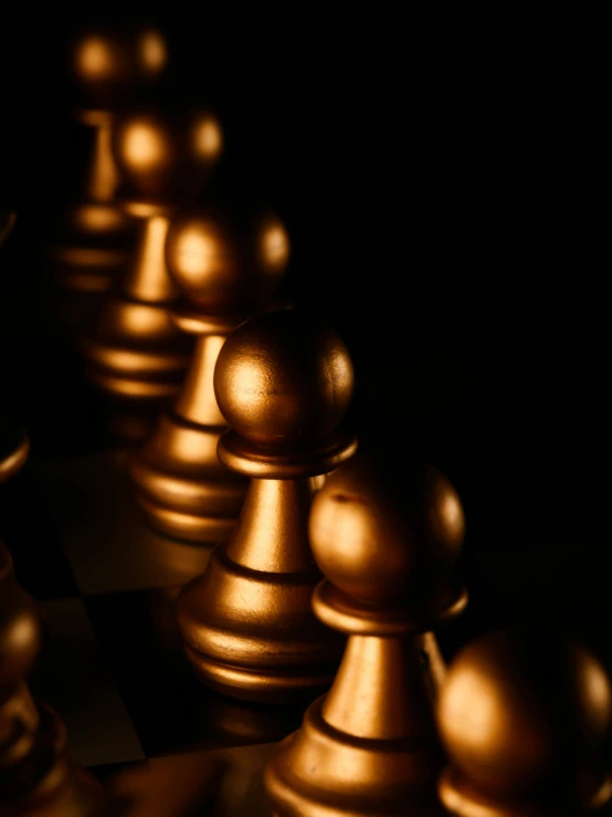 a group of chess pieces sitting on top of a chess board, gold bodypaint, thumbnail, up-close, dimly lit