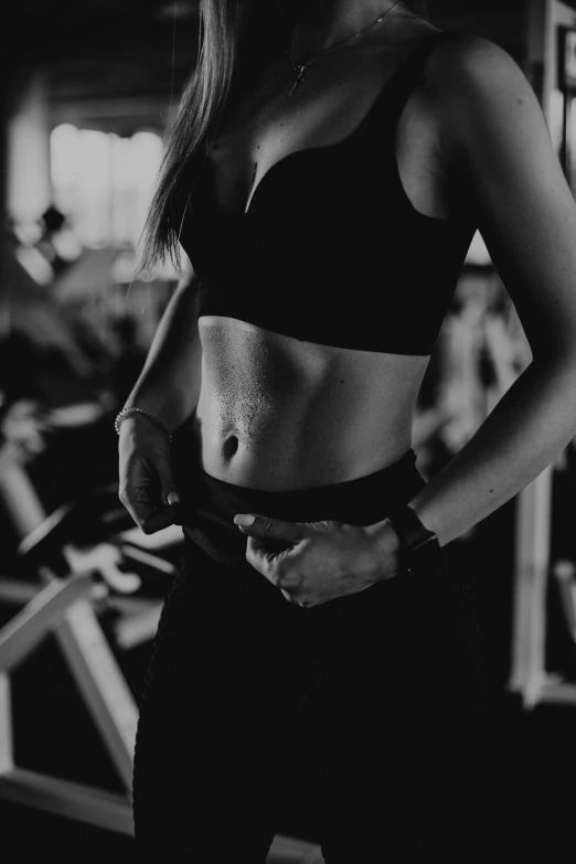 a black and white photo of a woman in a gym, pexels contest winner, midriff, female character, trimmed, mid 2 0's female