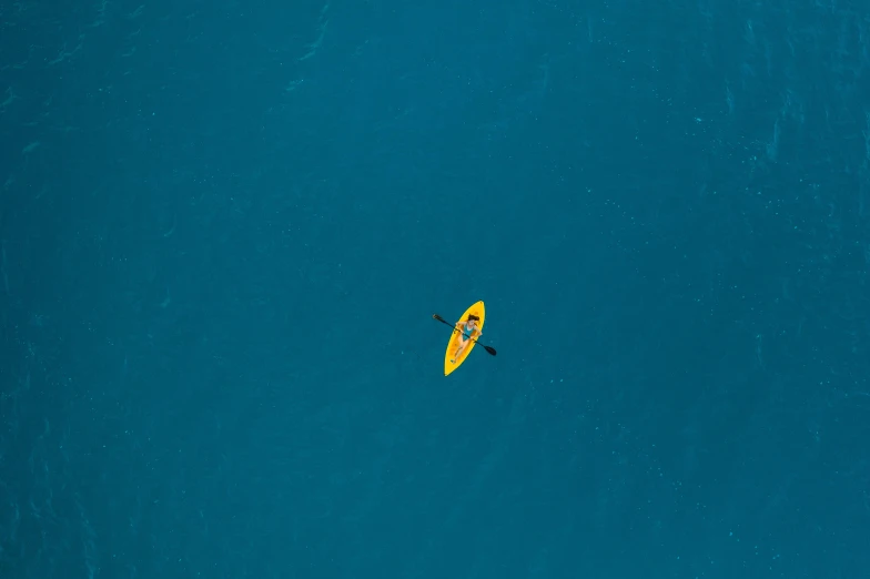 a person on a surfboard in the middle of the ocean, pexels contest winner, minimalism, yellow and blue, canoe, taken from a plane, dingy