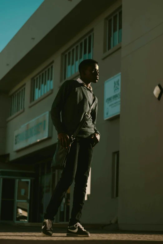 a man on a skateboard in front of a building, an album cover, pexels contest winner, dark skinned, looking away from camera, cinematic morning light, ( ( theatrical ) )