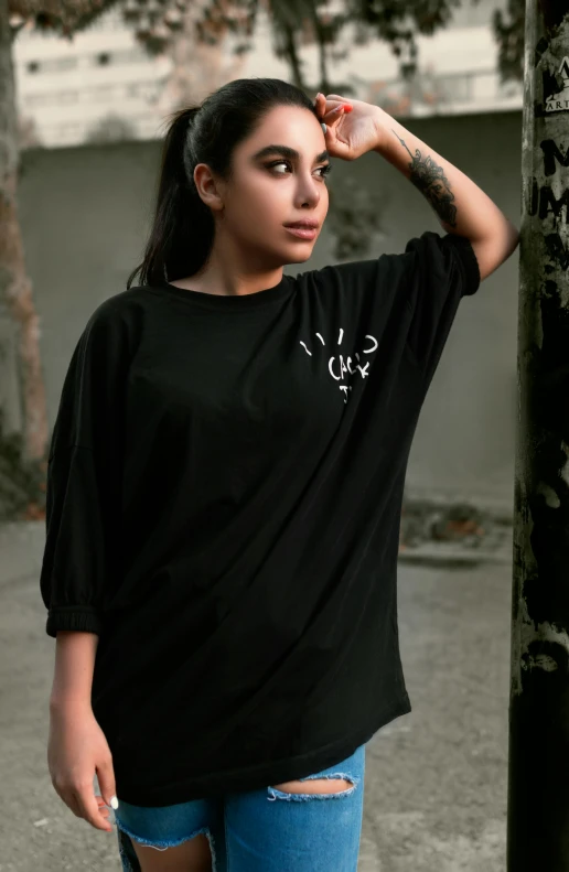 a woman standing on a street corner next to a pole, a portrait, inspired by Luo Mu, unsplash, lyco art, black t shirt, dolman, official product photo, with glowing runes on the body