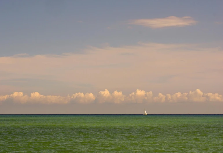 a sailboat in the middle of a large body of water, unsplash contest winner, minimalism, miami beach, cumulus, shades of green, late summer evening