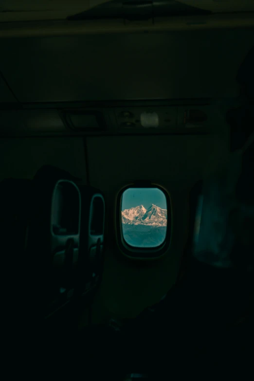 a person sitting in an airplane looking out the window, inspired by Elsa Bleda, snowy peaks, looking through a portal, the photo was taken from a boat, lit from behind