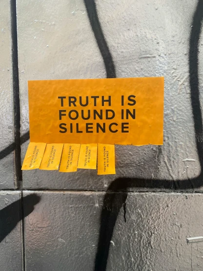 a yellow sticker that says truth is found in silence, a poster, trending on unsplash, street art, promo image, sentient fruit, rick owens, low quality photo