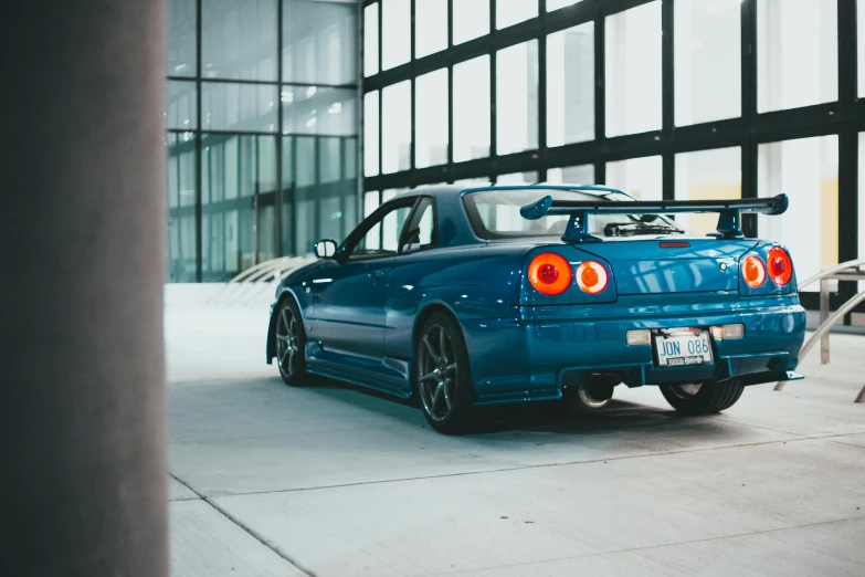 a blue car parked in front of a building, by Winona Nelson, pexels contest winner, in a modified nissan skyline r34, sports car in the room, garage kit, 15081959 21121991 01012000 4k