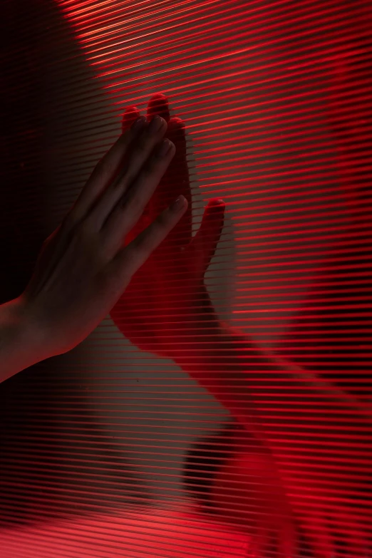 a person standing in front of a red light, a hologram, inspired by Nan Goldin, trending on pexels, interactive art, hands reaching for her, soft light through blinds, red shift render, black and red