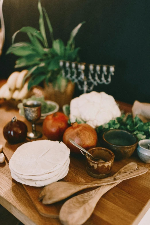 a wooden cutting board topped with lots of food, a still life, unsplash, renaissance, israel, historical image, dan eder, on kitchen table