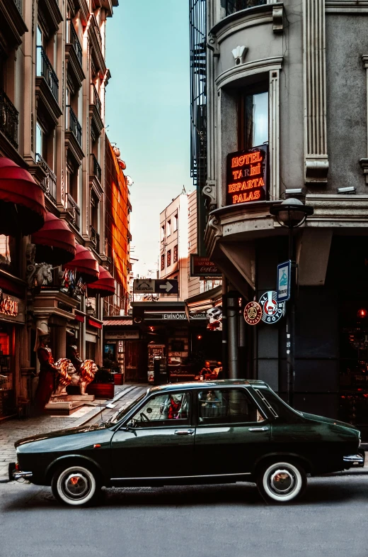 a black car driving down a street next to tall buildings, a photo, inspired by Elsa Bleda, pexels contest winner, art nouveau, dimly lit cozy tavern, istanbul, olive green and venetian red, colorful signs