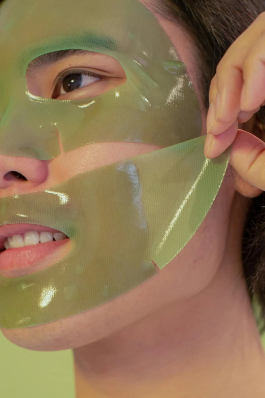 a woman putting a mask on her face, by An Gyeon, reddit, dynamic closeup, green skin!, translucent gills, asian man