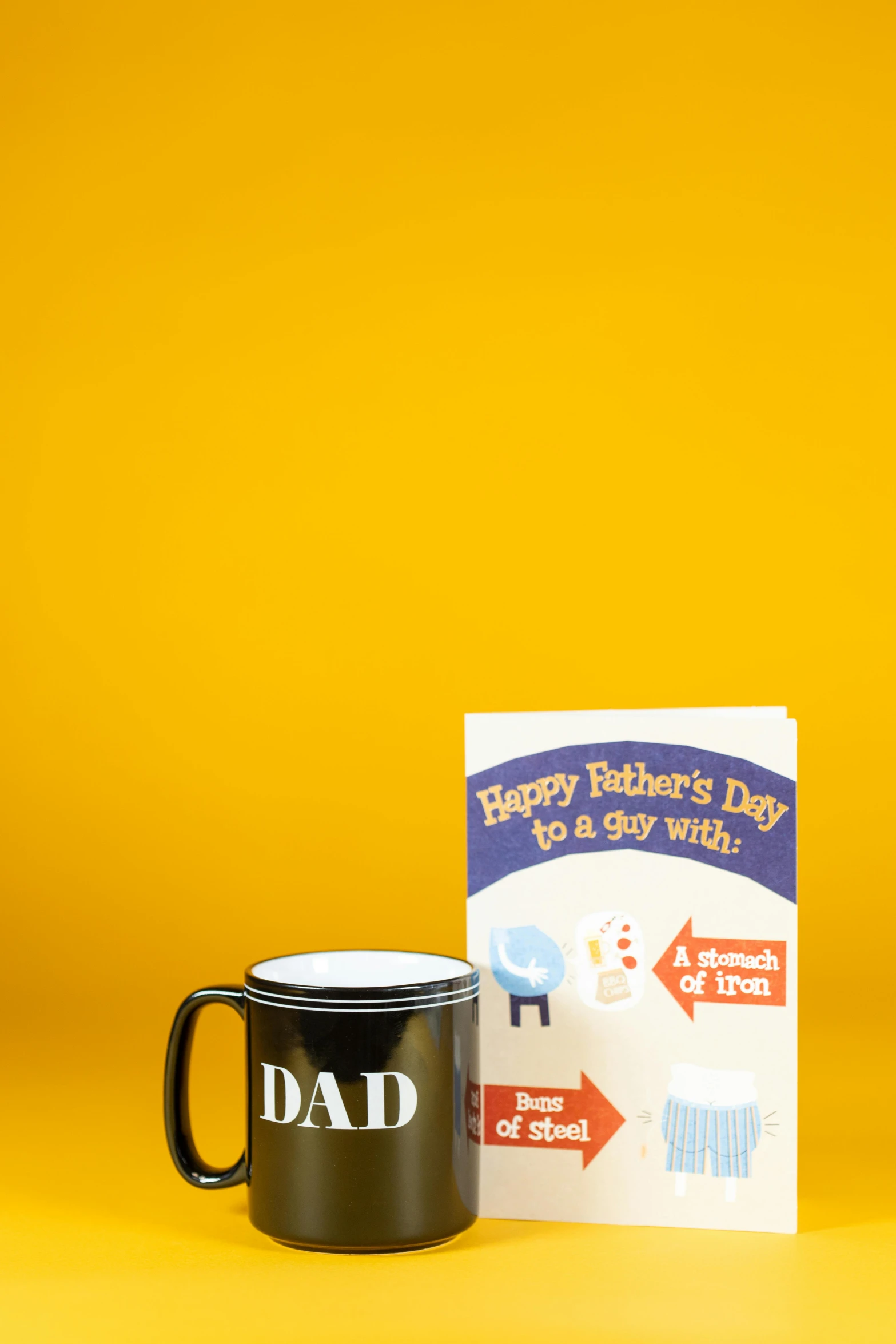 a black coffee mug sitting next to a book, by Paul Bird, dada, daddy/fatherly, greeting card, ap photo, pbr