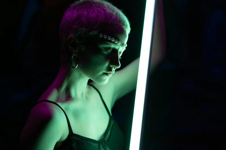 a woman holding a light saber in a dark room, inspired by Nan Goldin, light and space, green and purple studio lighting, rave otufit, bathing in light, profile picture 1024px