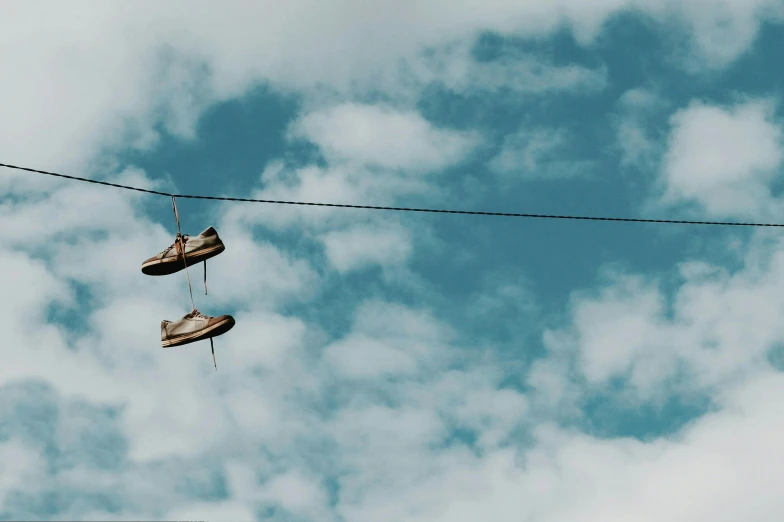 a pair of shoes hanging from a power line, unsplash contest winner, renaissance, floating in the sky, brown, 🤬 🤮 💕 🎀, thumbnail