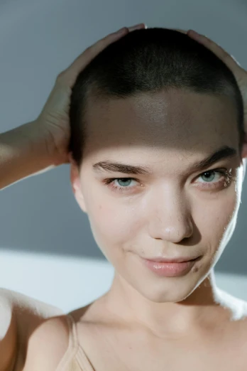 a woman with a shaved head posing for a picture, inspired by Elsa Bleda, trending on pexels, anya taylor joy, androgynous male, clean shaven wide wide wide face, taken in the late 2010s
