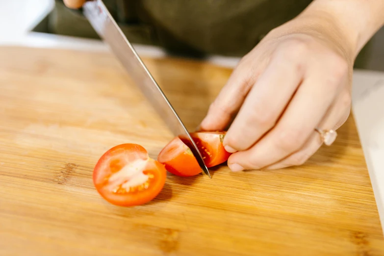 a person cutting a tomato on a cutting board, by Julia Pishtar, pexels contest winner, a folding knife, plating, youtube thumbnail, low detail