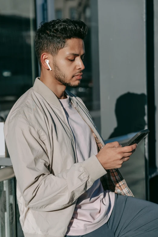 a man sitting on a bench using a cell phone, airpods, gradient brown to white, pictured from the shoulders up, curated collections