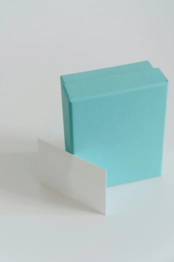 a blue box sitting on top of a white table, whole card, -step 50, seafoam green, opening shot