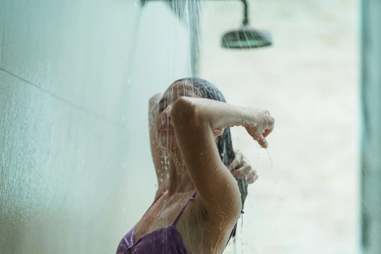 a woman in a bathing suit taking a shower, inspired by Elsa Bleda, pexels contest winner, fan favorite, low pressure system, teenage girl, monsoon