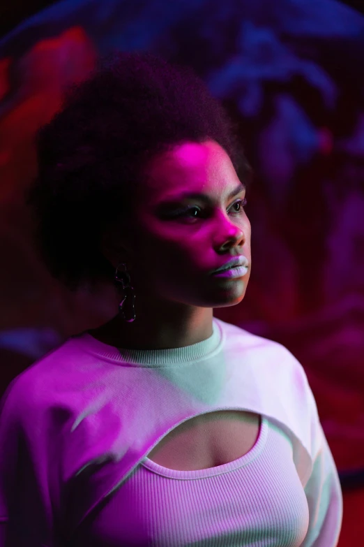 a woman standing in front of a painting, pexels, afrofuturism, extremely moody purple lighting, photo from a promo shoot, concert, avatar image