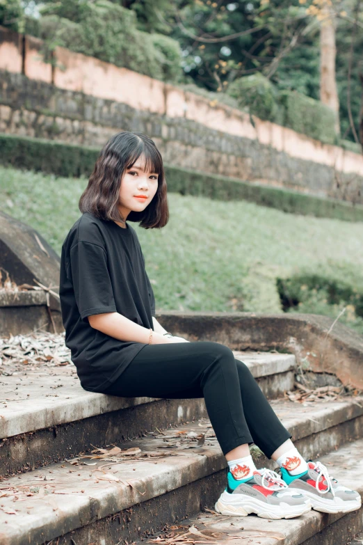 a woman sitting on some steps in a park, by Tan Ting-pho, pexels contest winner, realism, wearing black tshirt, girl cute-fine-face, vintage color, avatar image