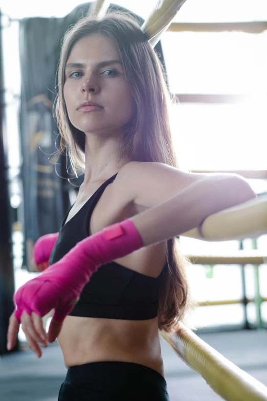 a beautiful young woman standing in a boxing ring, pexels contest winner, elongated arms, pink, in a dojo, promo image
