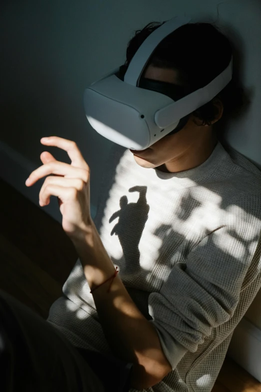 a man wearing a virtual reality headset in a dark room, trending on pexels, female image in shadow, white, praying, teenager