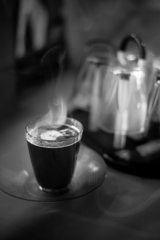 a cup of coffee sitting on top of a table, a black and white photo, inspired by Brassaï, very smoky paris bar, cooked, pouring, dark angel of coffee