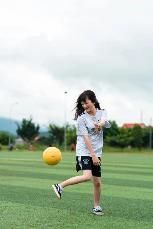 a girl kicking a soccer ball on a field, by Aguri Uchida, trending on dribble, laos, grey, educational, square