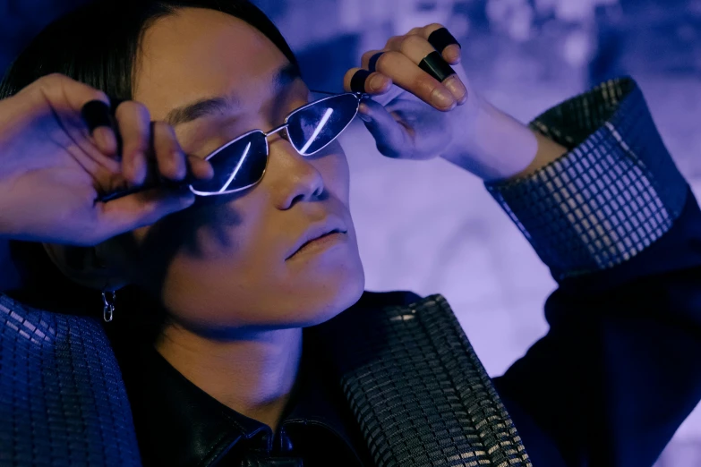 a close up of a person wearing glasses, inspired by Zhu Da, soft neon purple lighting, behind the scenes, with mirrorshades sunglasses, kevin hou