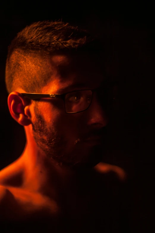 a man with glasses standing in the dark, inspired by Elsa Bleda, mid-shot of a hunky, full frame image, dramatic lighting - n 9, medium-shot