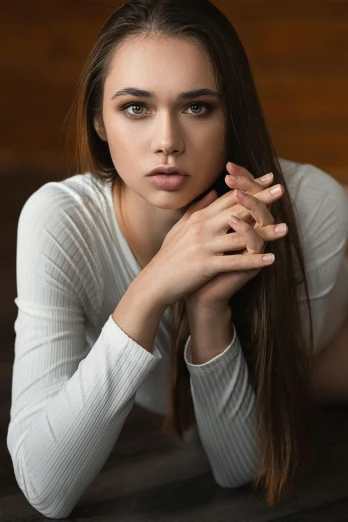a beautiful young woman laying on top of a wooden floor, a portrait, by Ivan Grohar, madison beer, medium close-up shot, hands retouched, looking serious